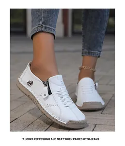 Mocasines informales blancos cosidos a mano con cremallera lateral y jeans azules