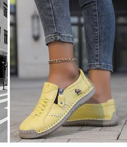 Vista detallada de zapatos planos amarillos cosidos a mano con cremallera lateral