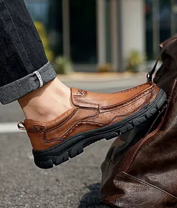 Close-up of brown leather men's casual slip-on shoes with textured finish and rubber sole