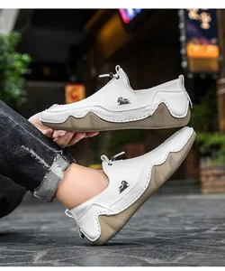Mocassini slip-on in pelle bianca con logo ariete e suola in gomma testurizzata in strada.