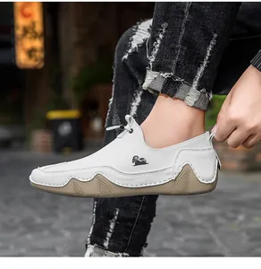 Vista laterale di scarpe in pelle bianca traspirante con logo ariete