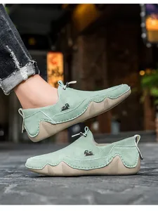 Vista dettagliata di mocassini in camoscio verde menta con logo capra e suola beige