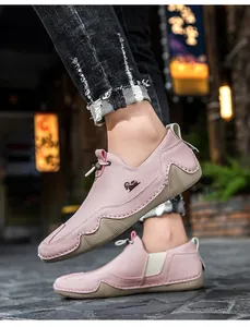 Dettaglio di scarpe casual slip-on rosa in pelle martellata con logo di capra.