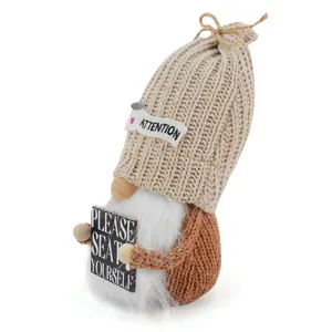 Detailed view of a knitted gnome doll holding a Please Seat Yourself sign ornament