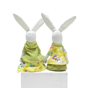 Rückansicht von zwei handgefertigten Osterhasen-Figuren in grün-gelben Outfits