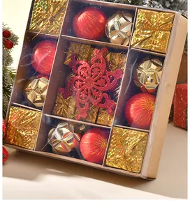 Nahaufnahme einer festlichen Geschenkbox mit roten und goldenen Weihnachtskugeln und Sternen.