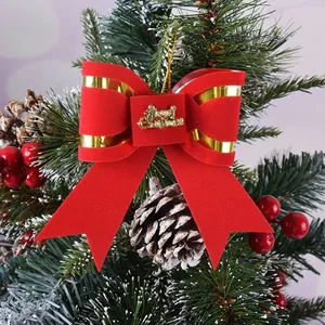 Detail view of red velvet Christmas bow with gold Merry Christmas script on tree