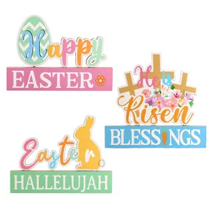 Set of three colorful wooden Easter table decorations with rabbit egg and cross designs
