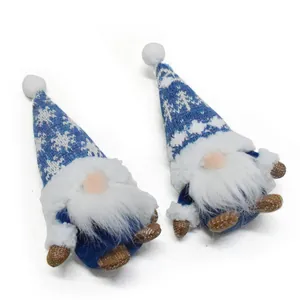 Primer plano de gnomos navideños azules con gorros de copos de nieve y barbas blancas.