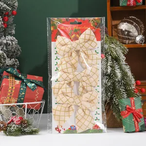 Detailed view of three beige Christmas bows with gold grid pattern in festive packaging.