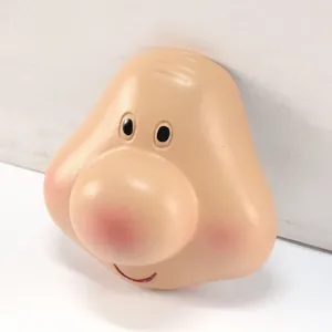 Macro vedetta di un viso di gnomo in resina con un grande naso rosa e un sorriso