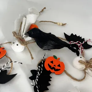 Vue détaillée des décorations d'Halloween avec un corbeau en plumes et fantômes en tissu