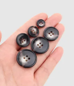 Close-up of premium dark marbled urea buttons in multiple sizes for high-end clothing
