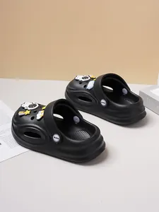 Detailed macro view of black children's clogs featuring cute astronaut and star charms