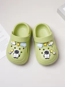 Close-up of light green kids' clogs featuring cute astronaut and star-themed charms