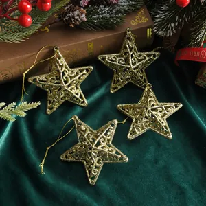 Set of four golden hollow star Christmas tree ornaments on dark green velvet background