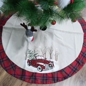 Detail van een kerstboomschort met rode ruitjesrand en een vintage vrachtwagenopdruk.