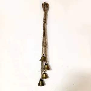 Vintage style metal bells string hanging on jute rope for rustic home and garden decoration