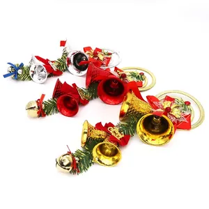 Detailed view of Christmas bell ornaments in gold, red, and silver with pine needles