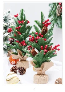 Close-up of mini Christmas trees with vibrant red berries and pine cones in burlap base