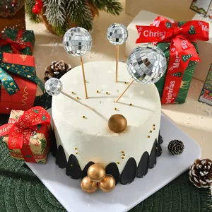 Detalle de adornos para tarta con bolas de discoteca plateadas en tarta blanca festiva