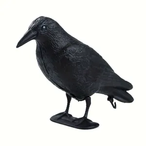Detailed side view of a realistic black plastic crow decoy for garden bird scaring