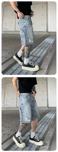 Street style detail of men's washed denim shorts with rhinestones and distressed rips