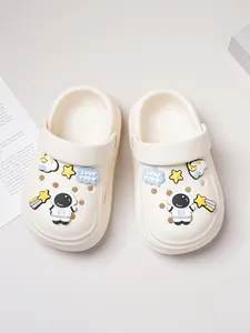 Close-up of cream kids clogs with cute astronaut and star charms detail