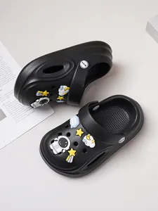 Detail of black children's clogs with astronaut and star space-themed charms.