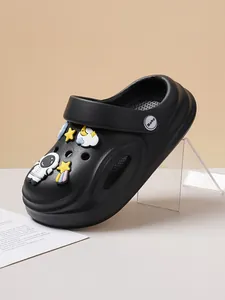 Detail view of black clog shoes with cute astronaut and star cartoon charms