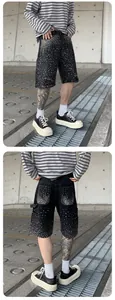 Detailed view of men's black cargo denim shorts with sparkling rhinestone embellishments