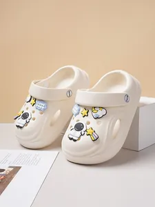 Close-up of cute cream clogs with astronaut and star charms on a minimalist background