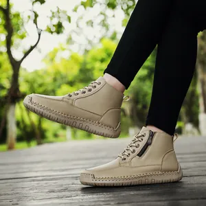 Macro view of khaki women's Martin boots featuring hand-stitched soles and side zippers