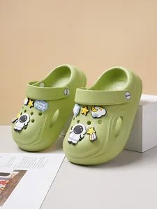 Detailed view of green kids clogs with astronaut and space themed decorative charms