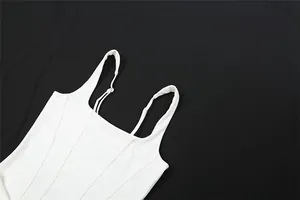 Close-up detail of a white square-neck dress with adjustable shoulder straps, stylish finish