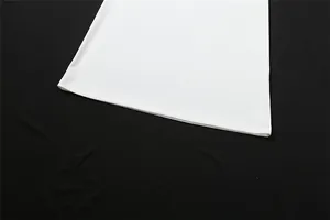 Detailed close-up showing the high-quality hemline stitching of a white bodycon dress