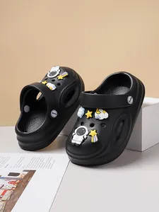 Detail view of black casual kids clogs featuring cute astronaut and star charms