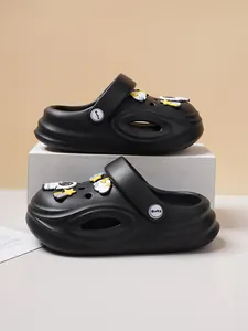 Detail of black kids clogs with astronaut charms and soft EVA material.