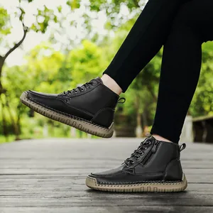 Close-up of black leather Martin boots featuring hand-stitched tan soles and side zippers.