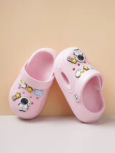 Detail of pink children's clogs featuring cute astronaut and star cartoon charms.