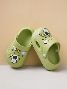 Detailed view of lime green children's clogs featuring cute astronaut and star charms