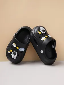 Detailed macro view of black children's clogs featuring cute 3D astronaut and star shoe charms