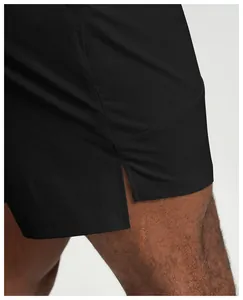 Close-up macro detail showing the side slit and fabric texture of black quick-dry men's sports shorts