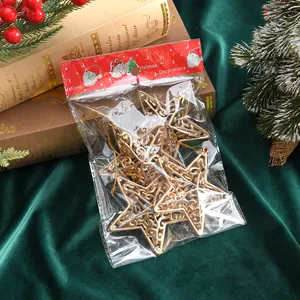 Detail of hollow gold star Christmas ornaments in clear packaging on festive green velvet