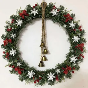 Close-up of a festive Christmas wreath featuring retro metal bells and snowy pine needles