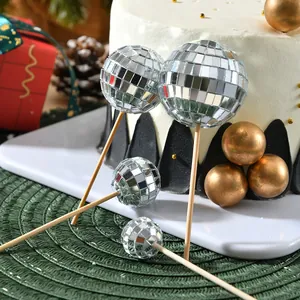 Primer plano de adornos para tartas de bolas de discoteca con espejo y palitos de madera
