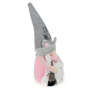 Detailed side view of a cute pink cat gnome plush doll holding a small white kitten friend
