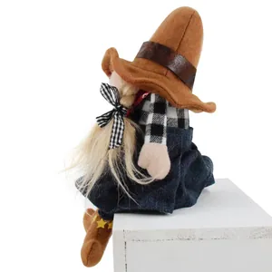 Side view of cowboy girl gnome plush doll with blonde braids sitting on a white box