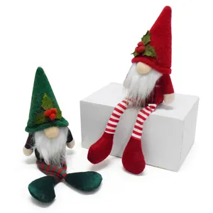 Handmade red and green Christmas gnomes with long legs sitting on white background