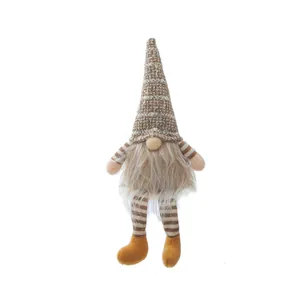 Macro detail view of a plush Christmas gnome with a tall hat and long white beard.